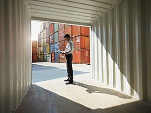 man standing in shipping and cargo container